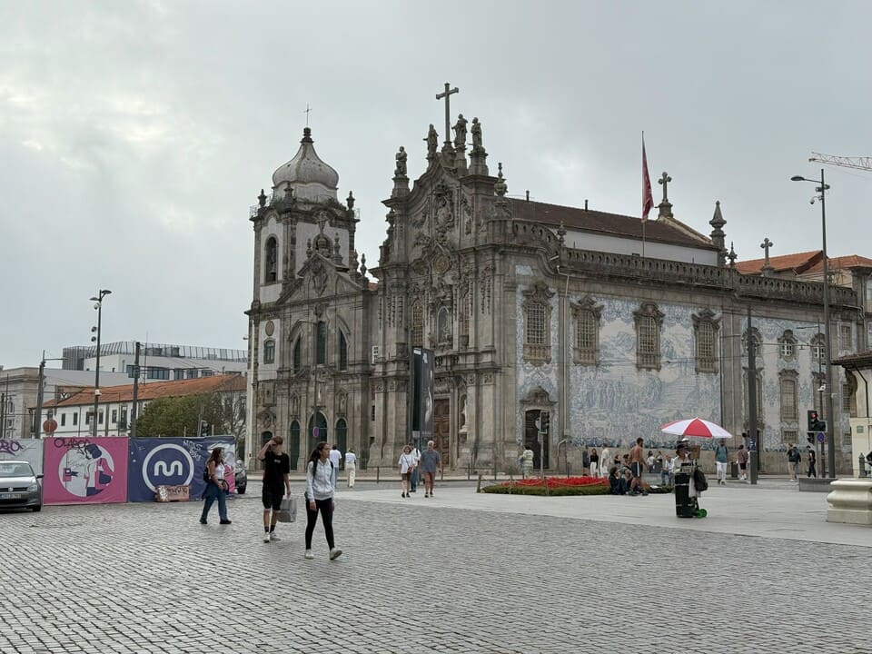 Facciata della Igreja do Carmo a Porto decorata con azulejos blu, in Praça de Carlos Alberto, con turisti che passeggiano.