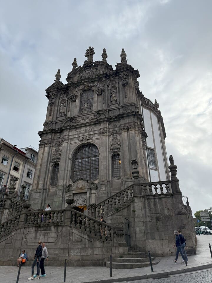 Facciata barocca della Igreja dos Clérigos a Porto, monumento storico con scalinate monumentali e dettagli architettonici.
