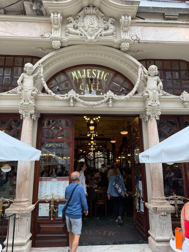 Facciata storica del Majestic Café di Porto, con dettagli in stile Art Nouveau e visitatori in attesa di entrare.