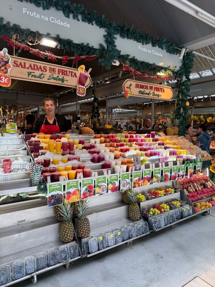 Bancarella colorata al Mercado do Bolhão di Porto con frutta fresca, succhi naturali e frullati esposti.
