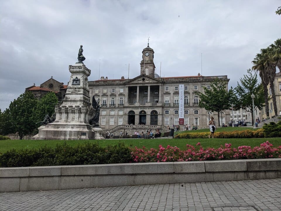 Facciata del Palácio da Bolsa a Porto, edificio neoclassico patrimonio UNESCO, con il monumento a Enrico il Navigatore in primo piano.