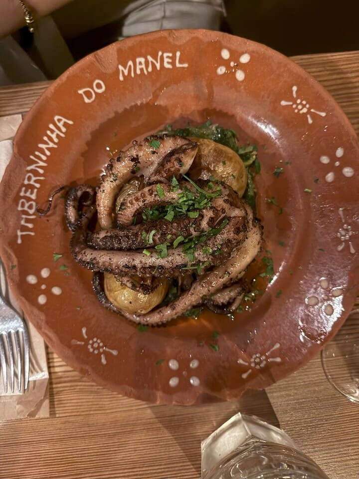 Piatto tipico portoghese di polpo alla griglia con patate e verdure servito al ristorante Taberninha do Manel a Porto.