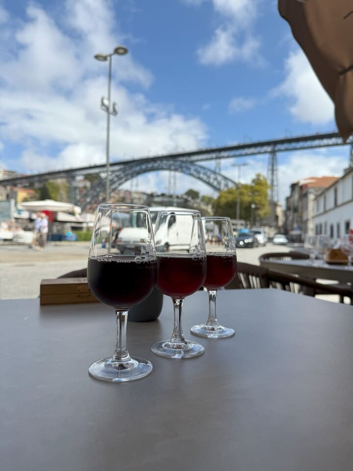 Degustazione di vino Porto in tre calici presso le Caves Cálem, con vista sul Ponte Dom Luís I a Porto.