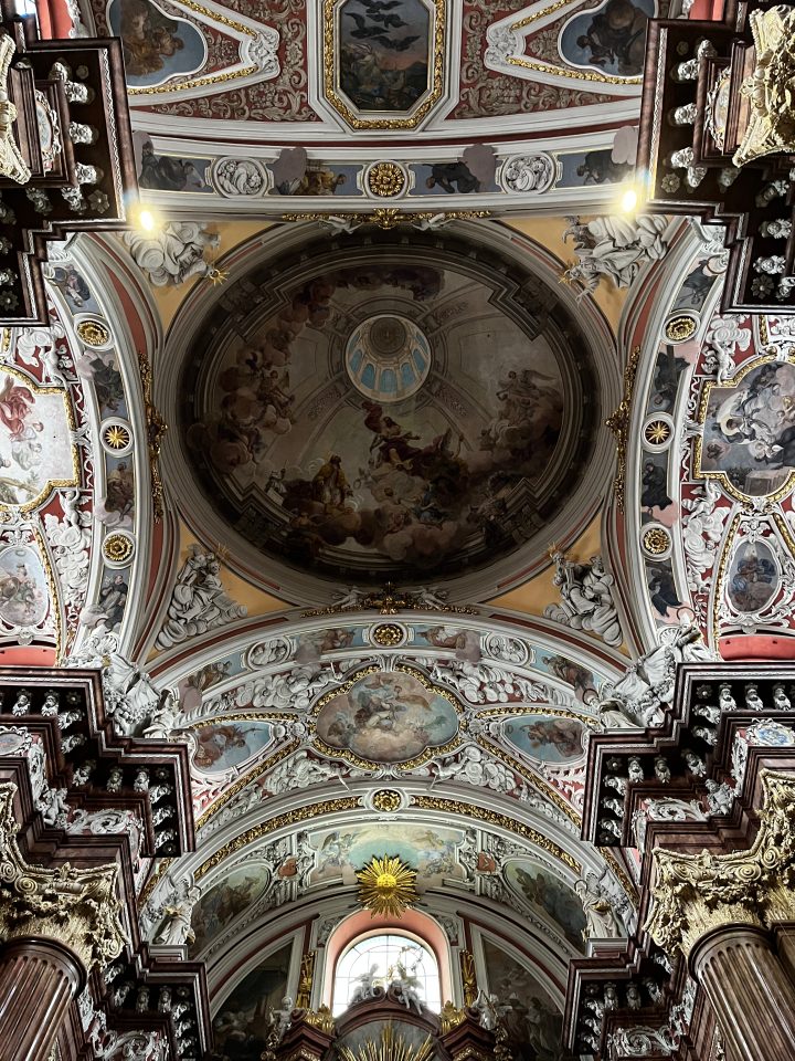 Interno barocco della Fara Poznańska, Chiesa di San Stanislao a Poznań, con affreschi e decorazioni riccamente ornate sulla volta.