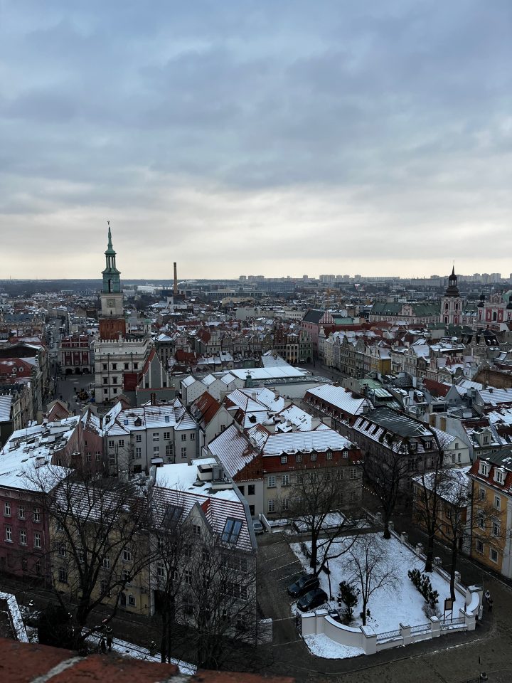 Vista panoramica di Poznań dalla torre del Castello Reale (Zamek Królewski), con i tetti innevati e il centro storico.