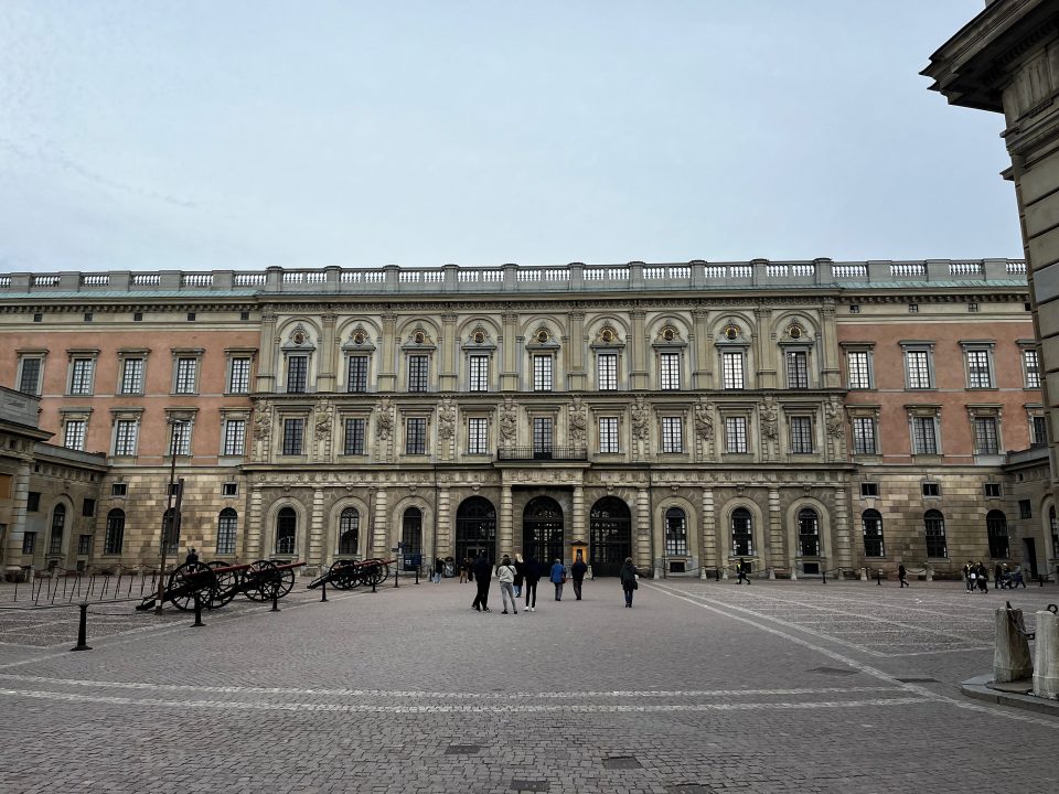 Facciata del Palazzo Reale di Stoccolma (Kungliga slottet) con turisti nella piazza antistante.