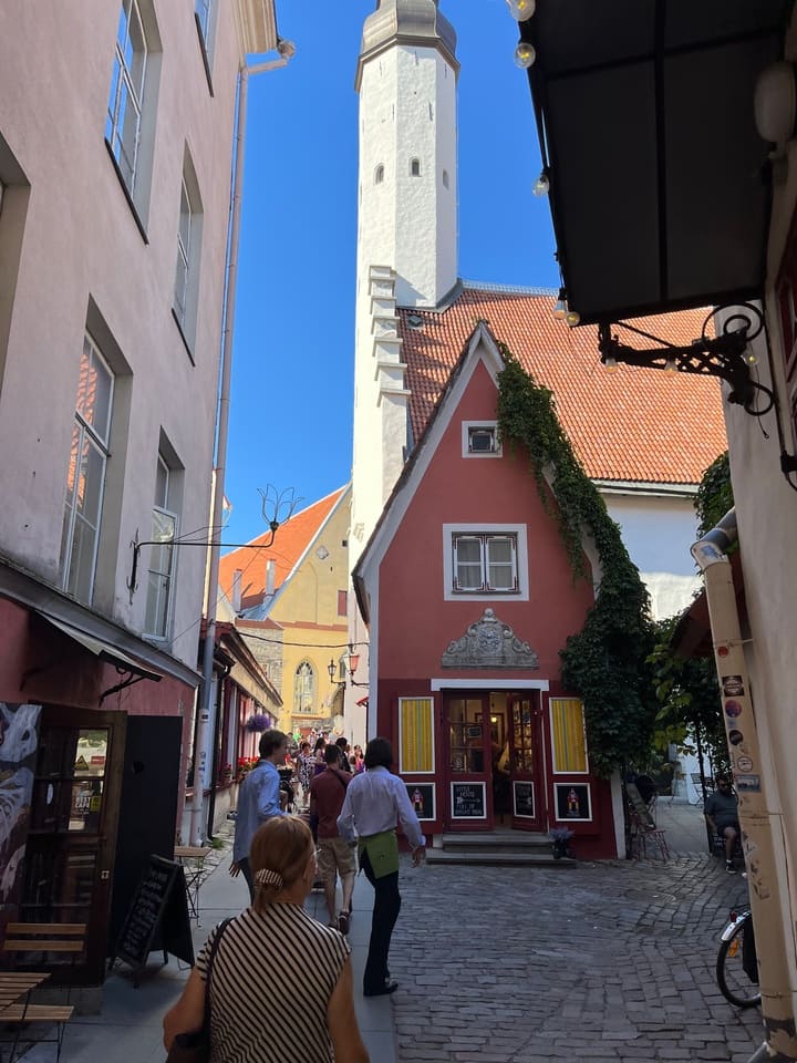 Via Pikk a Tallinn con case colorate e torre medievale sullo sfondo